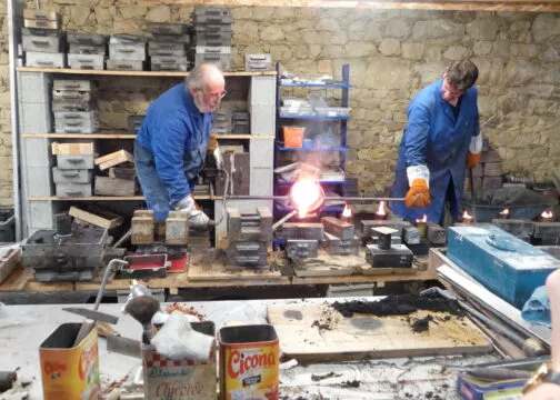 Deux personnes fondant du métal à Sion-les-Mines