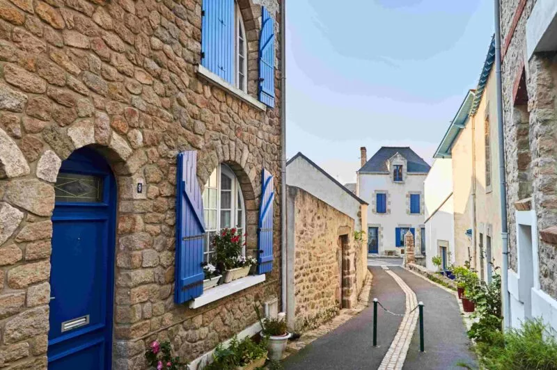 Les ruelles ombragées de Batz-sur-mer et ses maisons aux volets bleus.