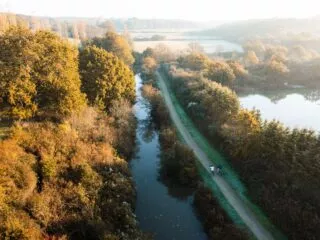 Vue aérienne d'un canal avec des cyclistes sur le chemin qui le longe