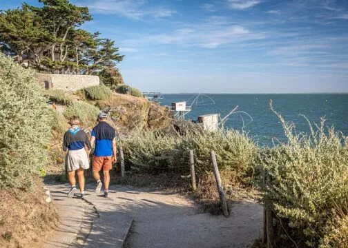 Un couple se balade sur un sentier côtier