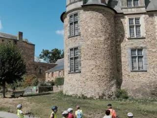 Groupe de cyclistes arrêtés au pied du château de Châteaubriant