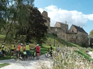 Des cyclistes font une pause devant le château de Chateaubriant.
