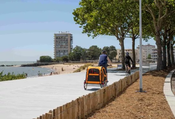 Un cycliste roule sur une piste aménagée sur le bord de la mer