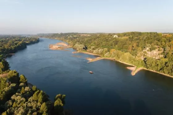 Une rivière coule au milieu d'un paysage vallonné et boisé