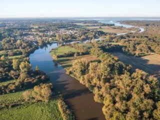 Une rivière qui serpente entre forêt et champs