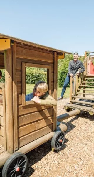 Des grands parents jouent avec leurs petits enfants sur un jeu en bois
