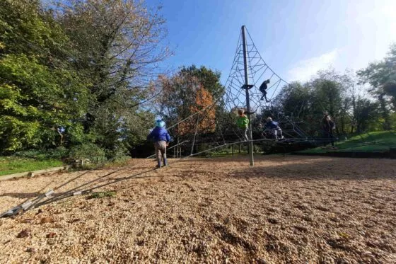 Enfants qui escaladent une structure de jeux de plein air du parc de loisirs