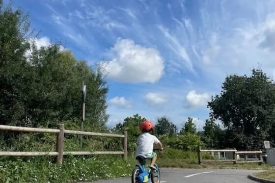 Un enfant à vélo sur la piste cyclable de l'île Pinette