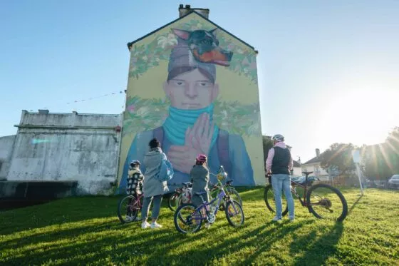 Des cyclistes admire une peinture murale dans une rue de Saint-Nazaire