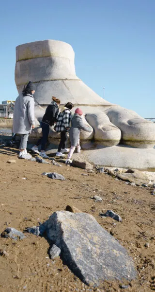 Une femme et des enfants découvrent l'oeuvre d'art Le Pied, le Pull-over et le Système digestif de Daniel Dewar et Gregory Gicquel.