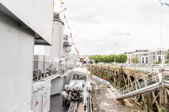 Vue du pont supérieur d'un bateau de guerre, avec la passerelle le reliant au quai