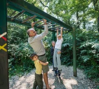 Des grands-parents s'amusent avec leurs petits-enfants sur un parcours santé.