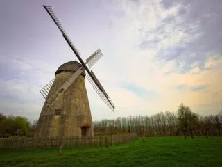 Un moulin à vent en pierre dans un paysage d'hiver