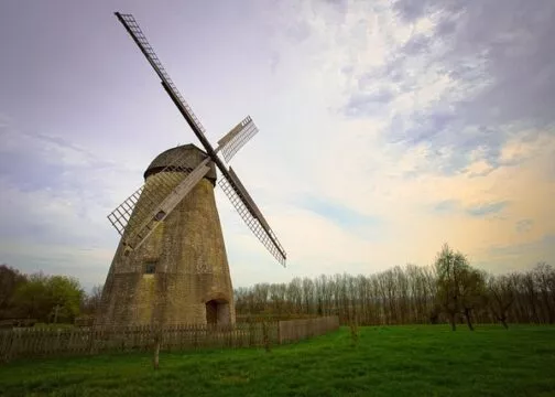 Un moulin à vent en pierre dans un paysage d'hiver