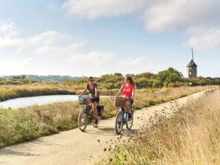 Deux cyclistes roulent sur une piste cyclable au milieu des marais de St Molf