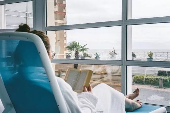 Une femme se détend à la thalasso de Pornic avec vue sur l'océan.