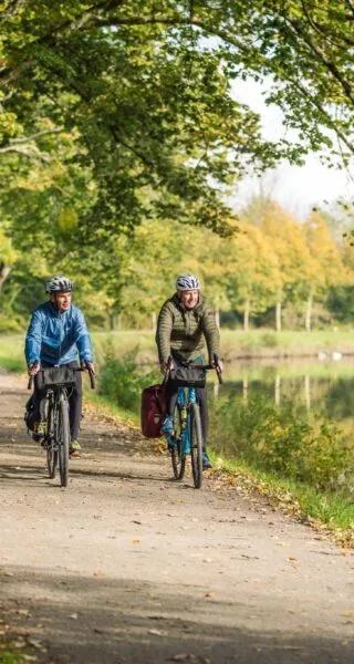 Deux hommes font du vélo en hiver le long du canal de Nantes à Brest, à Blain