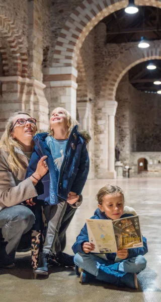 Une mère de famille fait découvrir l'abbatiale-Déas à ses3 jeunes enfants.