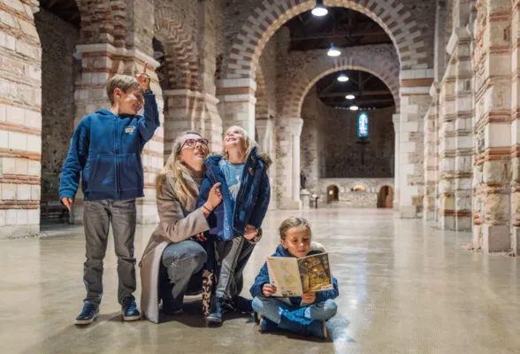 Une mère de famille fait découvrir l'abbatiale-Déas à ses 3 jeunes enfants.