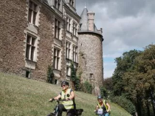 Deux cyclistes passant devant le château de Châteaubriant sur l'itinéraire de la Régalante