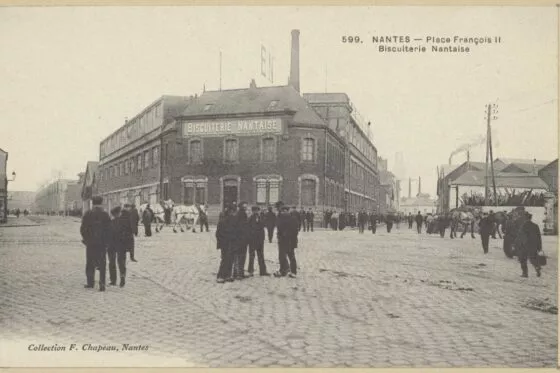 Une carte postale en noir et blanc d'une usine avec des ouvriers devant