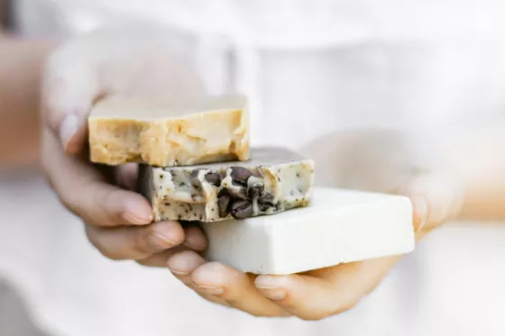 Une femme tient trois savons dans les mains